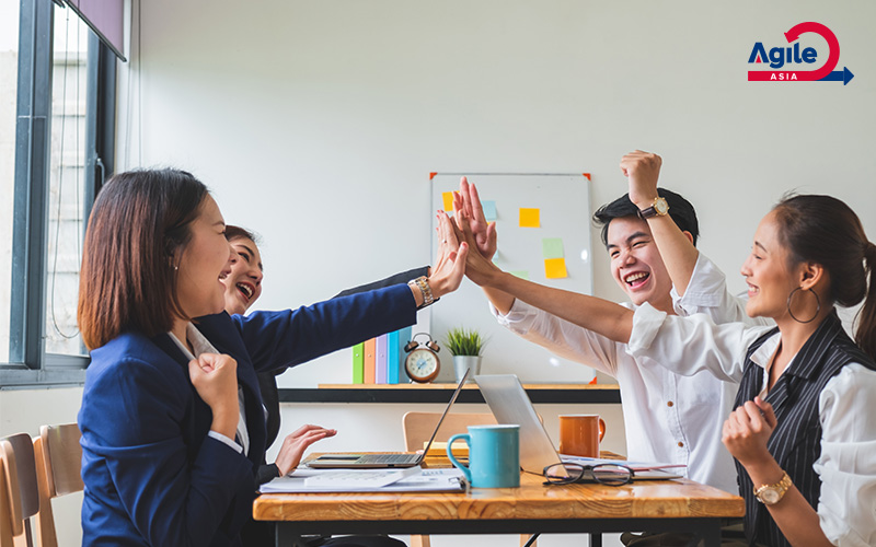 Agile Asia team high-fiving after a successful collaboration.